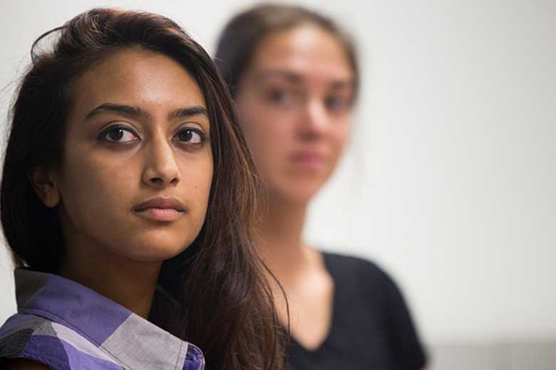 Photo of a Case Western Reserve University student looking at the camera, with another student in the background out of focus
